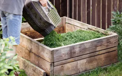 lawn clippings poured into compost bin in backyard of florida home