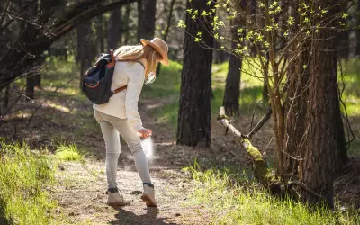 woman in florida applies spray so mosquitoes won't bite through her clothing
