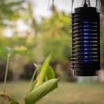 Mosquito trap hanging from a roof on a backyard patio